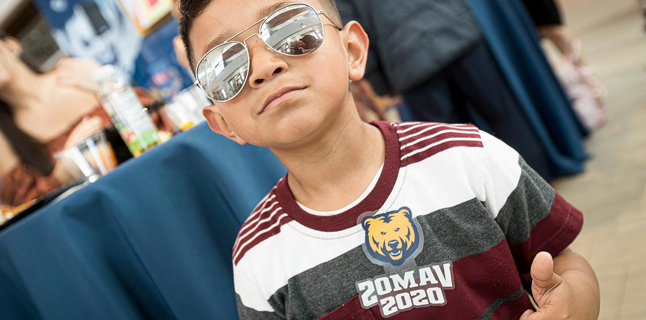 boy with sunglases and a t-shirt that says Vamos Osos