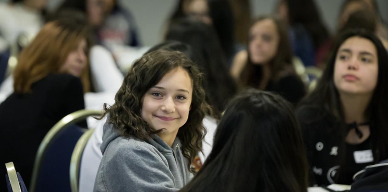 一位年轻的学生微笑着参加拉丁青年领导会议 